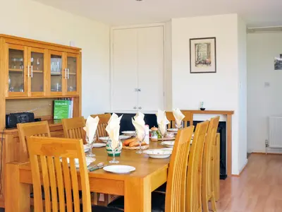 a dining room with a wooden table and chairs at Tir Gafr in Harlech