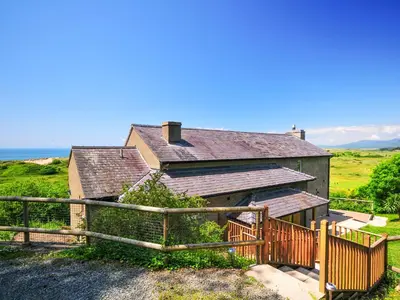 a house with a wooden fence in front of it at Tir Gafr in Harlech
