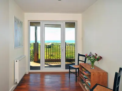 a living room with a sliding glass door with a balcony at Tir Gafr in Harlech