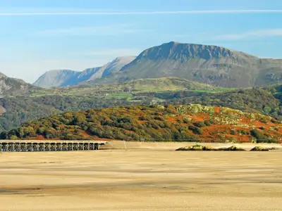 a mountain in the distance with a bridge in the foreground at Gors Y Gader in Llanelltyd