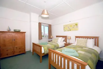 a bedroom with two beds and a dresser at Seascape in New Quay