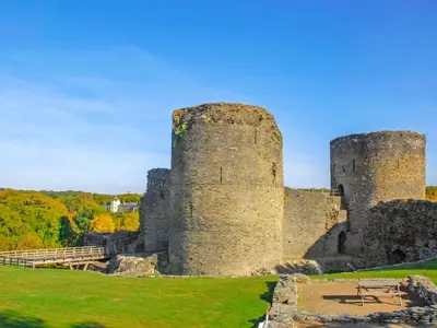 two towers of a castle with trees in the background at Seascape in New Quay