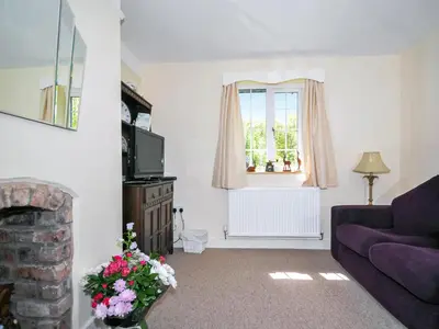 a living room with a couch and a window at Bryn Araul in Rhydymain