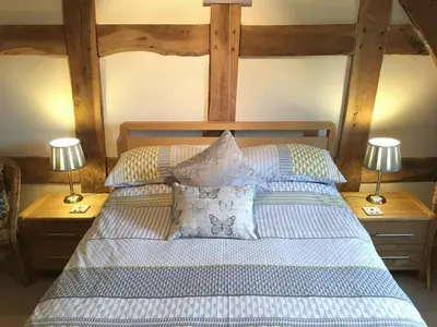 a bedroom with a bed with two lamps on tables at The Granary in Kingsland