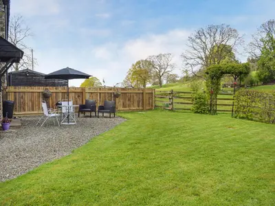 a backyard with a table and chairs and a fence at The Granary in Kingsland