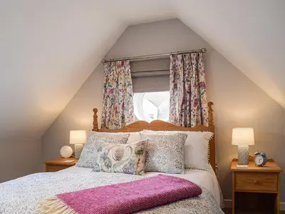 a bedroom with a bed with pillows and a window at Little Bank Cottage in Lane to Richards Castle