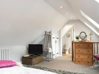 a bedroom with a bed and a dresser with a television at Little Bank Cottage in Lane to Richards Castle