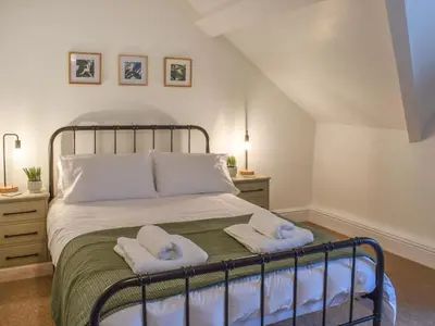 a bedroom with a bed with two towels on it at Ty Ni in Bala