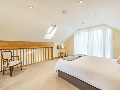 a bedroom with a large bed and a balcony at The Old Cow Shed At Ty Hir in Cilcennin
