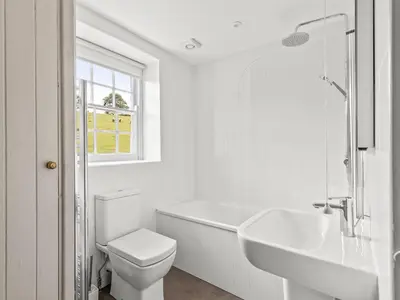 a white bathroom with a toilet and a sink at Croft Y Beudy in Henfynyw Upper