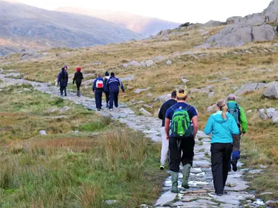 a group of people walking down a mountain trail at Arthfan in Llanelltyd