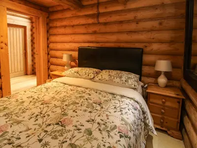 a bedroom with a bed in a log cabin at Brynallt Country Park in Ellesmere
