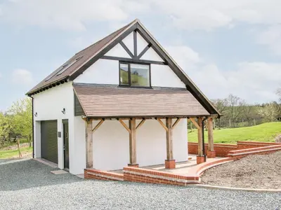 a white cottage with a gambrel roof at Gerry's Place in Church Stretton