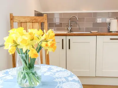 a vase of yellow flowers on a table in a kitchen at Gerry's Place in Church Stretton