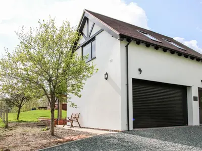 a white house with a garage at Gerry's Place in Church Stretton