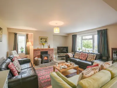 a living room with leather couches and a fireplace at Garth Ucha in Llanyblodwel