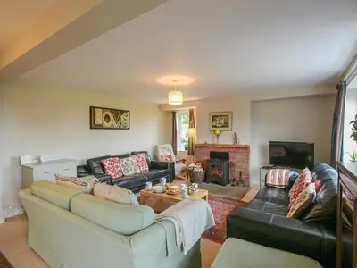 a living room with a couch and a fireplace at Garth Ucha in Llanyblodwel