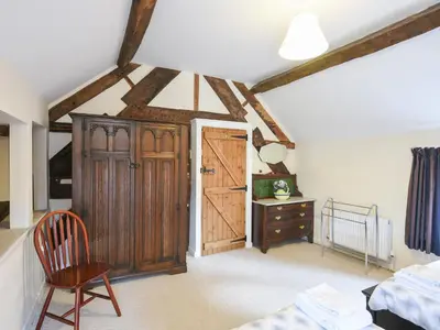 a bedroom with a wooden door and a bed and a desk at Garth Ucha in Llanyblodwel