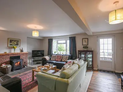 a living room with a couch and a fireplace at Garth Ucha in Llanyblodwel