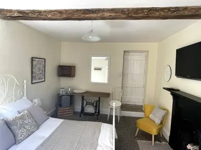 a bedroom with a bed and a desk and a television at Y Felin Bed and Breakfast and Smallholding in Caersws