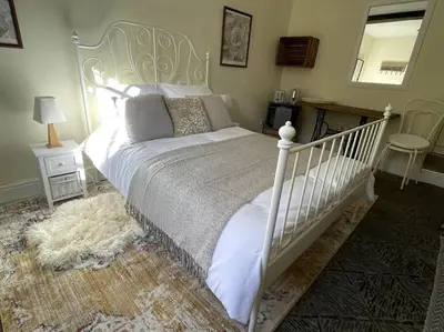 a bedroom with a white bed and a mirror at Y Felin Bed and Breakfast and Smallholding in Caersws