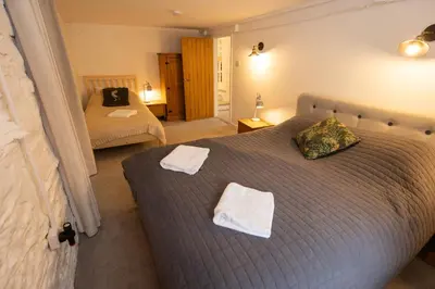 a bedroom with two beds and towels on a bed at The Coach House in Llangollen
