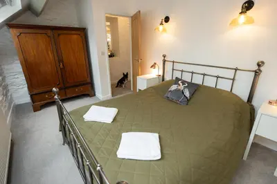 a bedroom with a bed with two towels on it at The Coach House in Llangollen