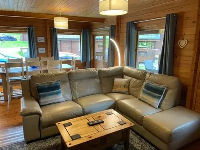 a living room with a couch and a coffee table at Luxury 3 bedroom, 3 bathroom lodge with hot tub in Llanbedr