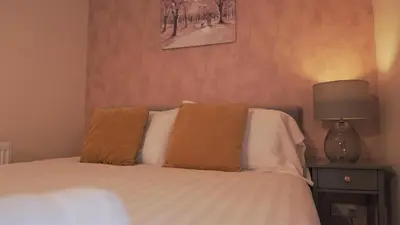 a bedroom with a bed with two pillows and a lamp at Meadow Terrace in Shrewsbury