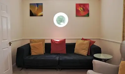 a black couch with colorful pillows on it in a room at Meadow Terrace in Shrewsbury