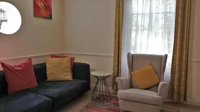 a living room with a black couch and a chair at Meadow Terrace in Shrewsbury