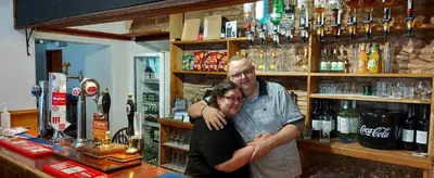 a man and a woman standing in a bar at Dinas Castle Inn (The Dragons Back) in Brecon
