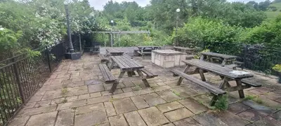 a patio with wooden benches and a picnic table at Dinas Castle Inn (The Dragons Back) in Brecon