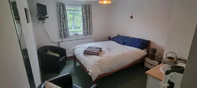 a small bedroom with a bed and a chair at Dinas Castle Inn (The Dragons Back) in Brecon