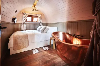 a bedroom with a bed and a bath tub at Romantic Croft with Private Hot Tub in Shrewsbury