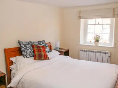 a bedroom with a white bed and a window at 138C Old Star and Garter Mews in Ludlow