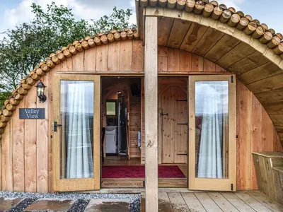 an entry to a wooden house with an arched doorway at Valley View - Uk34178 in Cilycwm