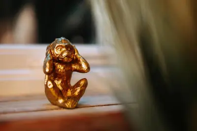 a small gold figurine of a monkey sitting on a table at Boutique Shrewsbury Suites in Shrewsbury