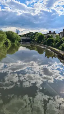 a river with a reflection of clouds in the water at Boutique Shrewsbury Suites in Shrewsbury