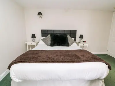a bedroom with a large bed with two night stands at Triangle Inn Coachouse in Rhayader