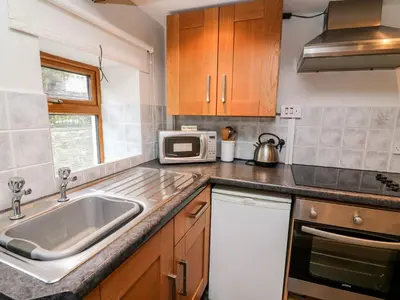 a kitchen with a sink and a microwave at Triangle Inn Coachouse in Rhayader