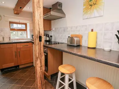 a kitchen with a counter and some stools in it at Triangle Inn Coachouse in Rhayader