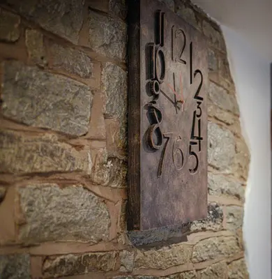 a clock on the side of a brick wall at Cosy cottage in rural Culmington, Ludlow in Culmington