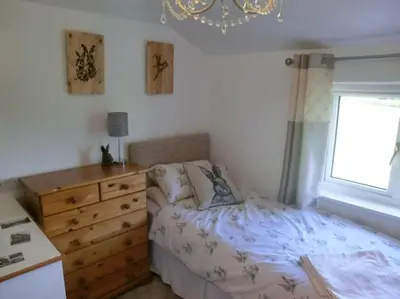 a bedroom with a bed and a dresser and a window at Cosy cottage in rural Culmington, Ludlow in Culmington