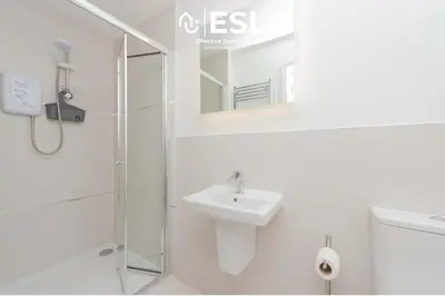 a white bathroom with a sink and a shower at Studio 1, First Floor Town Centre Apartment in Shrewsbury