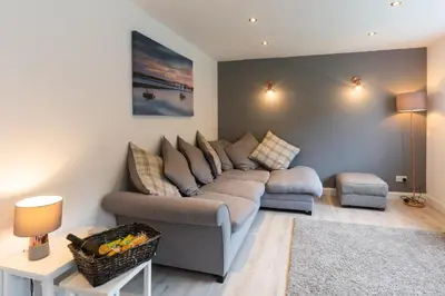 a living room with a couch and a table at Stunning Pet-Friendly Home with Hot Tub less than one minute walk from Barmouth Beach in Barmouth