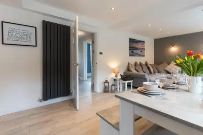 a living room with a table and a couch at Stunning Pet-Friendly Home with Hot Tub less than one minute walk from Barmouth Beach in Barmouth