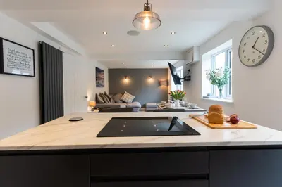 a kitchen with a sink and a living room at Stunning Pet-Friendly Home with Hot Tub less than one minute walk from Barmouth Beach in Barmouth
