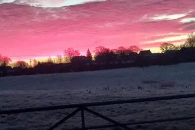 a field with a fence and a pink sky at 1 Bed Lodge-Sleeps 4-Pet Friendly-Free Parking in Hereford