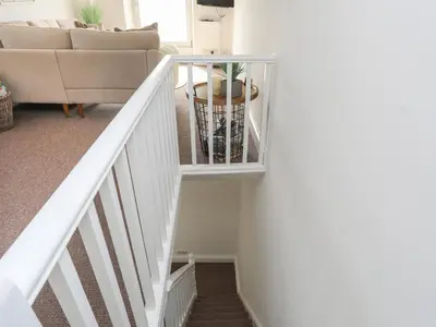 a stair case in a living room with a couch at Arran House in Barmouth